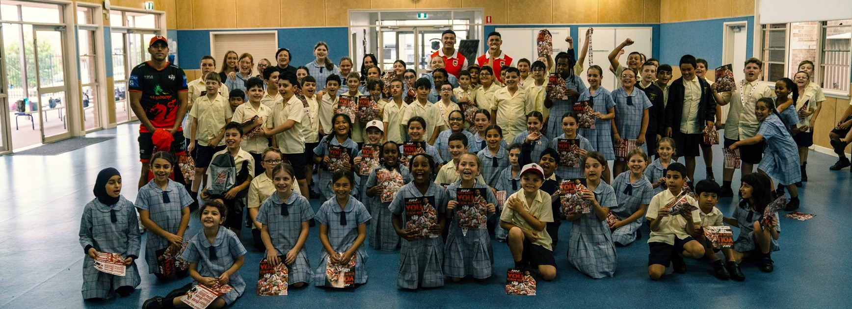 Tyrell Sloan, Sione Finau & Savelio Tamale pose for a group shot with the St Francis of Assisi Catholic Parish Primary School kids.