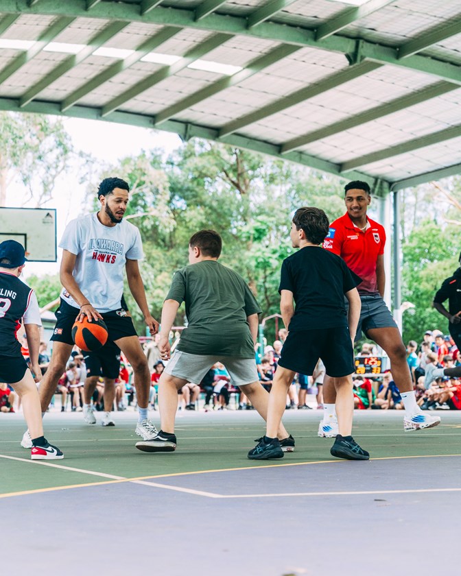 Hawks' Tyler Harvey and Dragons' Loko Pasifiki Tonga shooting hoops at Hayes Park Public School.